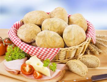 Bread buns in a basket, ham and cheese