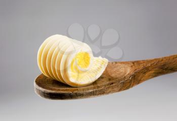 Closeup of a butter curl on a wooden spoon 
