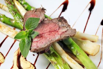 Slices of roast beef and asparagus