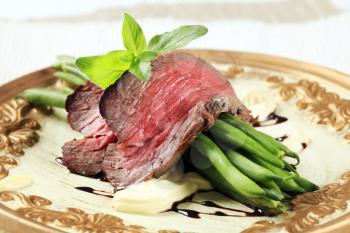 Slices of roast beef and string beans