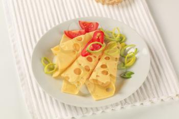 Slices of Swiss cheese sprinkled with spring onion 