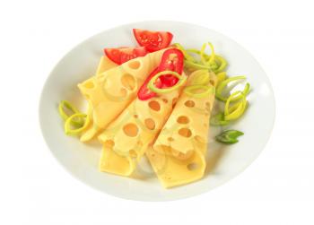 Slices of Swiss cheese sprinkled with chopped leek