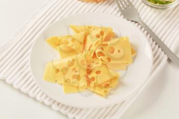 Thin slices of Swiss cheese on a plate