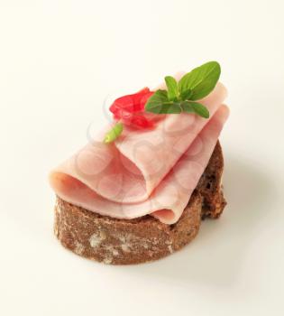 Thin slice of ham on brown bread