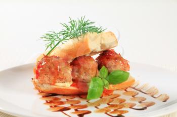 French loaf stuffed with meatballs and topped with red sauce