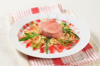 Pork fillet and spaghetti with raspberry balsamic reduction and rocket