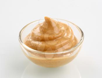 Swirl of spicy mustard in a small glass bowl