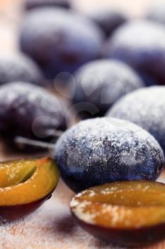 Ripe plums sprinkled with powdered sugar - detail