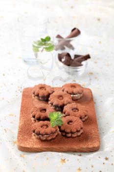 Chocolate cookies with cream filling on a cutting board