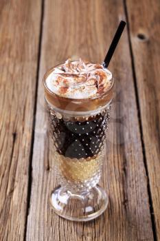 Coffee drink topped with whipped cream and mutmeg