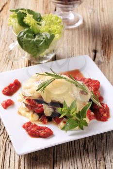Tomato and aubergine lasagna topped with cheese sauce