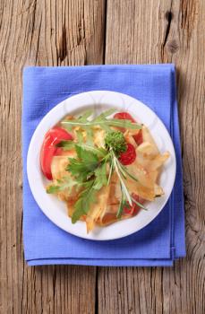 Sheet pasta with tomatoes and salad greens 