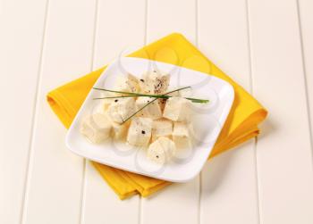 Cubes of marinated feta cheese on a plate