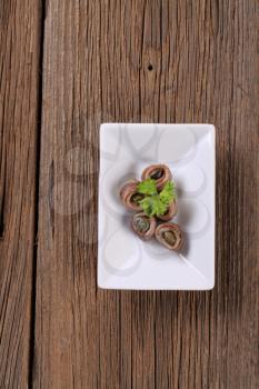 Rolled up anchovy fillets filled with capers