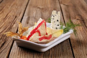 Delicious cheeses garnished with raspberry balsamic reduction