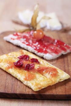 Two slices of crispbread with strawberry and apricot preserves