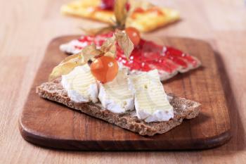Variety of crisp bread with cheese and jam