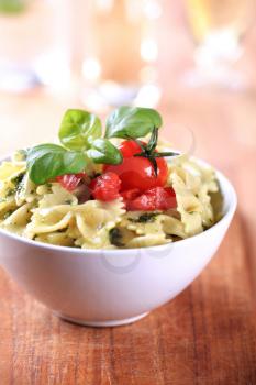 Bowl of bowtie pasta with pesto and tomatoes 