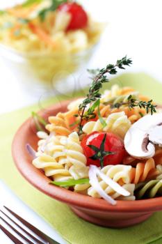 Tricolor corkscrew pasta in a terracotta bowl