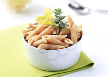 Bowl of whole wheat pasta tubes - closeup