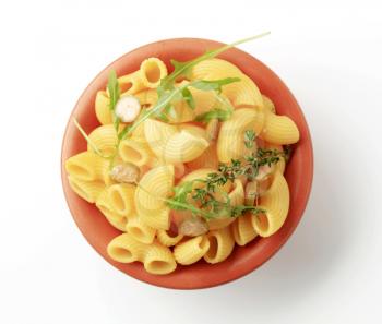 Bowl of macaroni with sliced capers and rocket