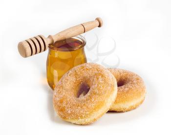 Fresh donuts, a jar of honey and a wooden dipper