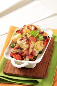 Fish and vegetable casserole topped with cheese