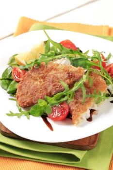 Fried fish on a bed of fresh salad