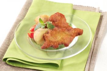 Fried dinosaur-shaped fish nuggets with new potatoes