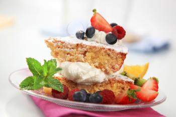 Slices of sponge cake with cream cheese and fruit