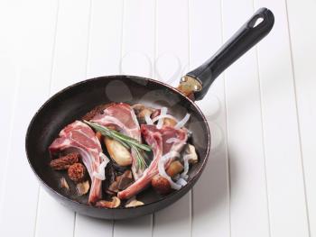 Lamb chops and mushrooms on a frying pan