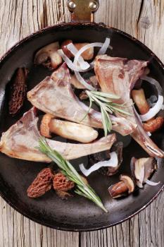 Lamb chops and mushrooms in a frying pan
