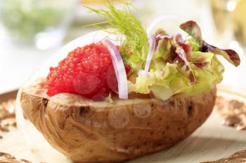 Baked potato and red caviar garnished with lettuce