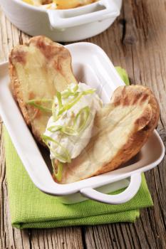 Baked potato halves with sour cream and spring onion