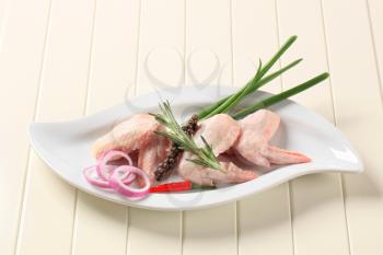 Raw chicken wings and other ingredients on a plate