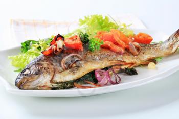 Herb-stuffed trout with tomatoes and green salad
