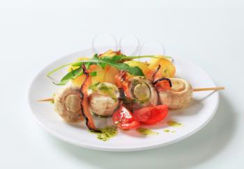 Skewer of button mushrooms with crispy bacon and potatoes