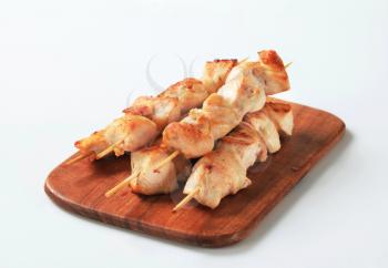 Chicken skewers on cutting board