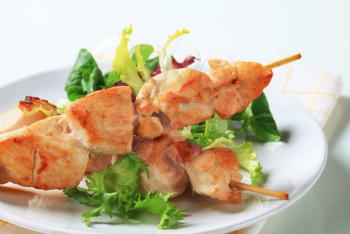 Chicken skewers and mixed salad greens