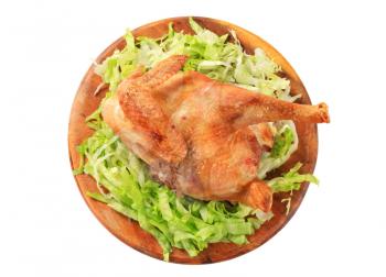 Crispy skin roast chicken with shredded lettuce on cutting board