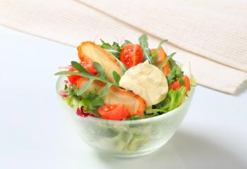 Green salad with fried cheese and salad dressing