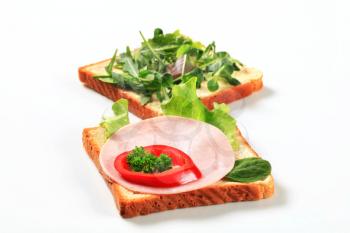 Open faced sandwiches with ham and salad greens