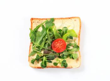 Slice of bread with mixed salad greens
