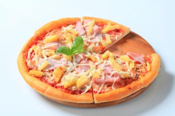 Fresh baked Pizza Hawaii on cutting board