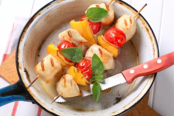 Grilled chicken chunks with cherry tomatoes and yellow pepper on skewers