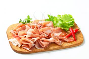 Thin slices of Prosciutto di Parma on cutting board