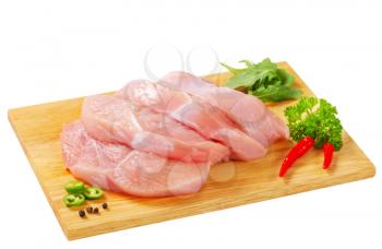 Slices of skinless turkey breast  meat on cutting board