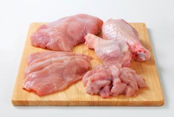Raw turkey meats and cuts on cutting board