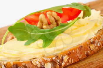 Slice of whole grain bread with butter and walnuts
