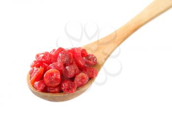 Dried red cherries on wooden spoon